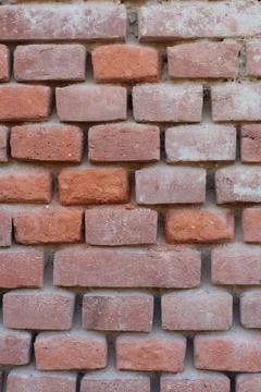 Unmaintained old brick wall made of orange old bricks with chipped plaster Stock Photos