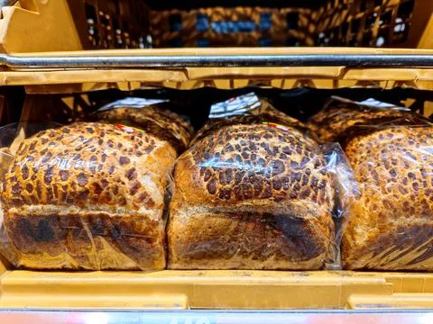 Unmarked slices of bread wrapped in plastic are on a supermarket shelf Stock Photos