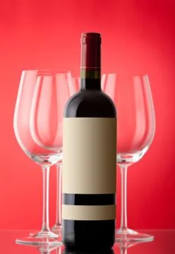 Unopened wine bottle on a red background Stock Photos