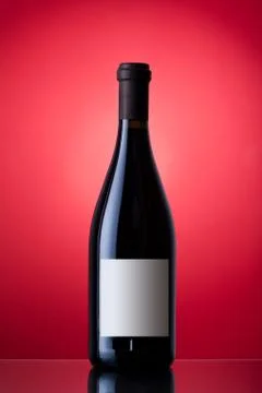 Unopened wine bottle on a red background Stock Photos