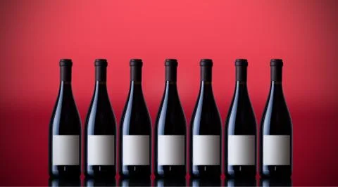 Unopened wine bottles on a red background Stock Photos