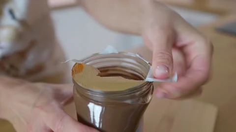 Unpacking the nut paste. Spoon in a jar of nut paste. Stock Footage 276294694
