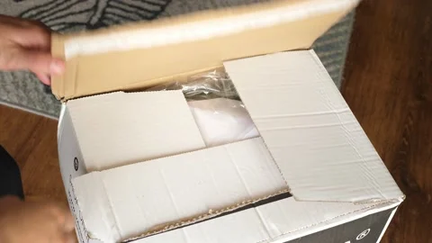 Unpacking opening an order package of clothes bought online Stock Footage 134732935