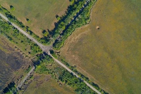 Unpaved dirt road intersection through green fields and agricultural countr.. Stock Photos
