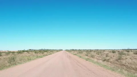 Unpaved dirt road stretching through expansive arid outback landscape under.. Vídeos de archivo 337787767