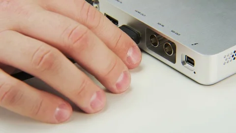 Unplugging Black Cable from a Device Stock Footage 70996862