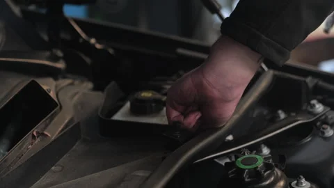Unplugging a connector under the hood of a car. Close up hands. Stock Footage 337879305