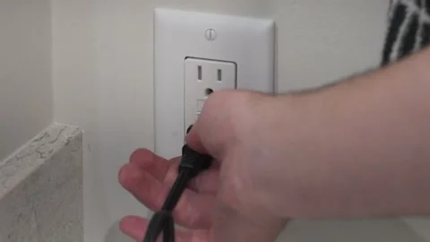 Unplugging a cord from a bathroom socket in slow motion. Stock Footage 313057780