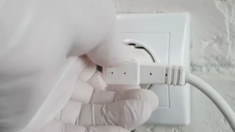 Unplugging in an Electrical Power Cord with Plug from a Wall Socket. Stock Footage 206978036