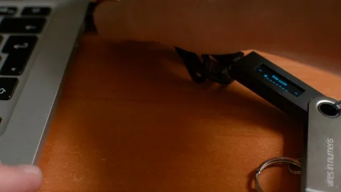 Unplugging Ledger Nano cold hardware Bitcoin cryptocurrency wallet device from 스톡 동영상 93941352