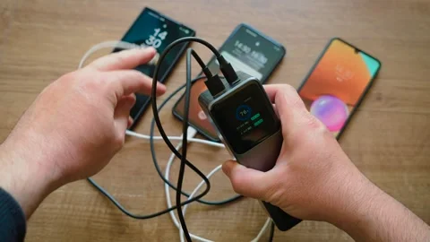 Unplugging smartphone cables from power bank stopping charging for connected Stock Footage 340905362