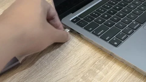 Unplugging a USB-C adapter from a modern notebook computer. Close-up. Stock Footage 293127687
