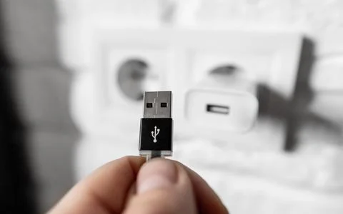 Unplugging USB cable from power adapter. Disconnect USB cord from the cellphone Stock Photos
