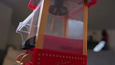 Unpopped corn kernels falling inside a vintage red popcorn Stock Footage 334716571