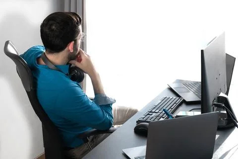 Unrecognisable middle-aged man working in office. View through the window Stock Photos