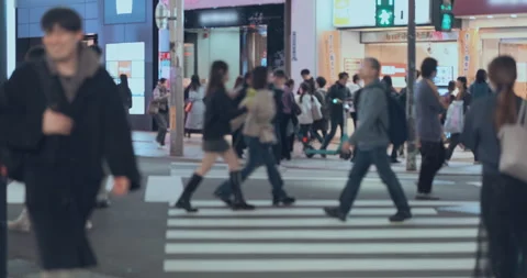 Unrecognisable people crowd crossing zebra crossing on busy urban street at nigh Stock Footage 334836618
