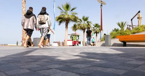 Unrecognisable tourists wearing masks walking near the beach . Stock Footage