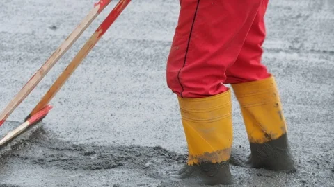 Unrecognised worker levelling concrete with a rake Stock Footage 102343792