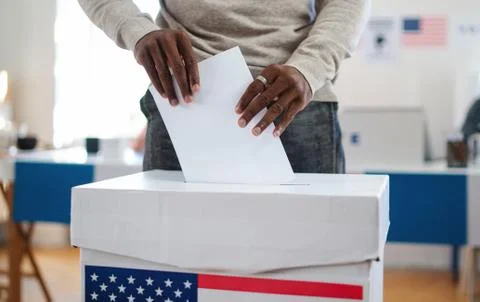 Unrecognizable african-american man putting his vote in the ballot box, usa Stock Photos