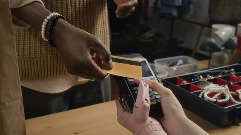 Unrecognizable African American Using Credit Card to Pay for Secondhand Clothes Stock Footage 328509697