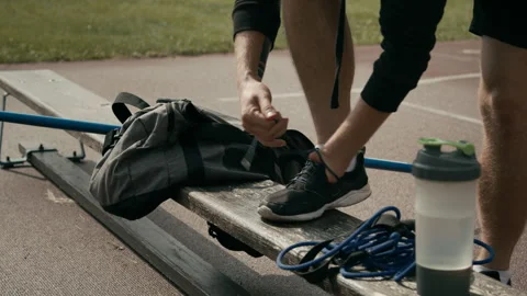 Unrecognizable Athlete with Limb Difference Tying Shoelaces before Workout Video stock 297949542