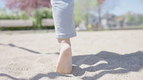 Unrecognizable barefoot toddler trying to sit on swing in the park. Stock Footage 242192591