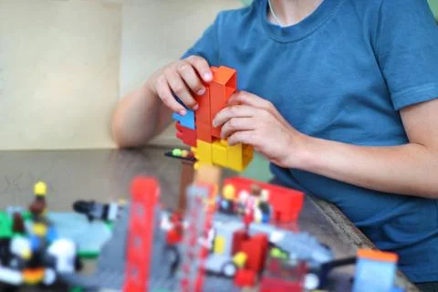 An unrecognizable boy assembles multi-colored constructor Stock Photos