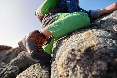 Unrecognizable boy with backpack climbing rocks in nature Stock Photos