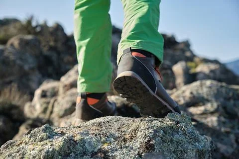 Unrecognizable boy with backpack climbing rocks in nature Stock Photos