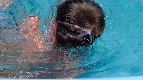 Unrecognizable boy swims in the pool on a sunny day Stock Footage 167285156