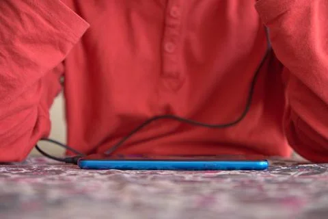 Unrecognizable boy using smart phone. Focus on the phone Stock Photos