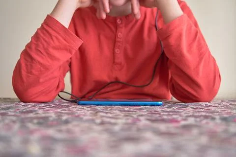 Unrecognizable boy using smart phone. Focus on the phone Stock Photos