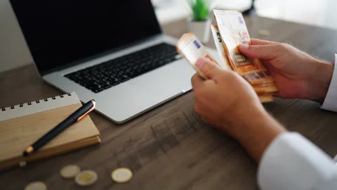 Unrecognizable businessman counting a stack of euro banknotes at an office .. Stock Footage 340022038