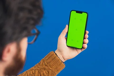 Unrecognizable caucasian guy with a beard and glasses holding a mobile phone Stock Photos