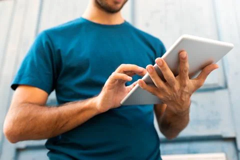 Unrecognizable caucasian man using digital tablet outdoors. Stock Photos