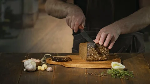 Unrecognizable chef cuts black bread on slices or sticks to prepare beer snacks Stock Footage 94587894