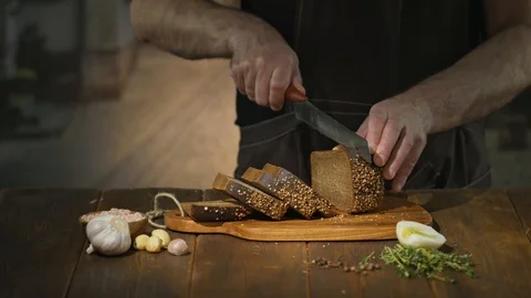 Unrecognizable chef cuts black bread on slices or sticks to prepare beer snacks Stock Footage 94589026