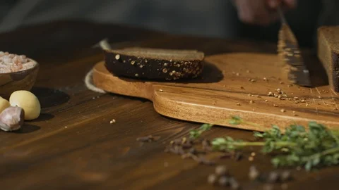 Unrecognizable chef cuts black bread on slices or sticks to prepare beer snacks Stock Footage 94590795