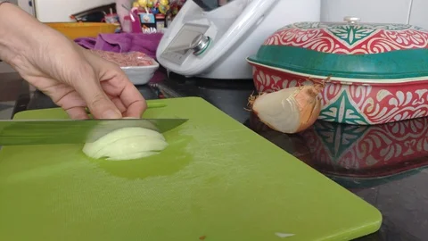 An unrecognizable chef cutting onions in the kitchen at home. Home cooking co Stock Footage 129229802