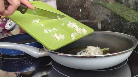 An unrecognizable chef making onion stir-fry in the kitchen at home. Home coo Stock Footage 129229785