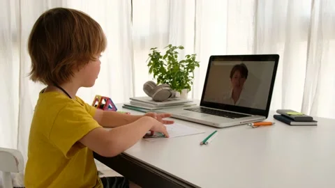 Unrecognizable child having video call with teacher on laptop indoors Video stock 136729216