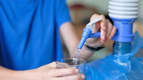 An unrecognizable child pouring water from a table cooler Stock Footage 207194269