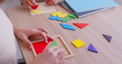Unrecognizable children engaged in team work, joining colourful geometic shapes Stock Footage 348083243