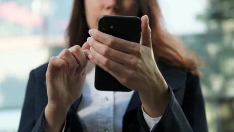 Unrecognizable Close-up woman's hand using a smartphone against office building Stock Footage 278547157