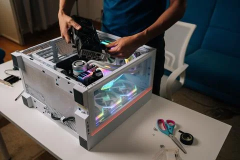 Unrecognizable computer technician installing new graphics card into modern Stock Photos