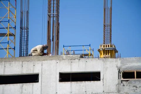 Unrecognizable construction worker on the wall of a new building on the backg Stock Photos