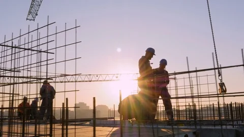 Unrecognizable construction workers on the top of the building at sunset. Stock Footage 83925183