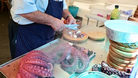 Unrecognizable cook cuts and prepares octopus Galician style Stock Footage 211311637