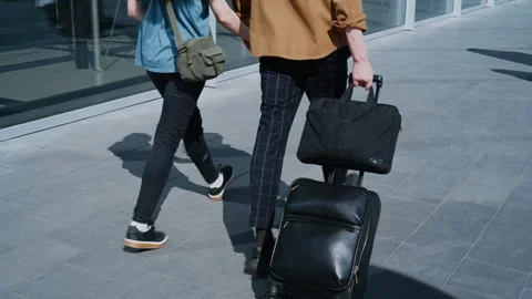 Unrecognizable Couple from Behind Walking Hand in Hand with Suitcase Near 库存影片 334567378