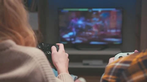Unrecognizable Couple Competing with White and Black Gamepads at Home Stock-Footage 342782394